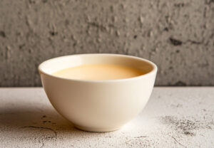 Un bol blanc rempli de crème anglaise crémeux